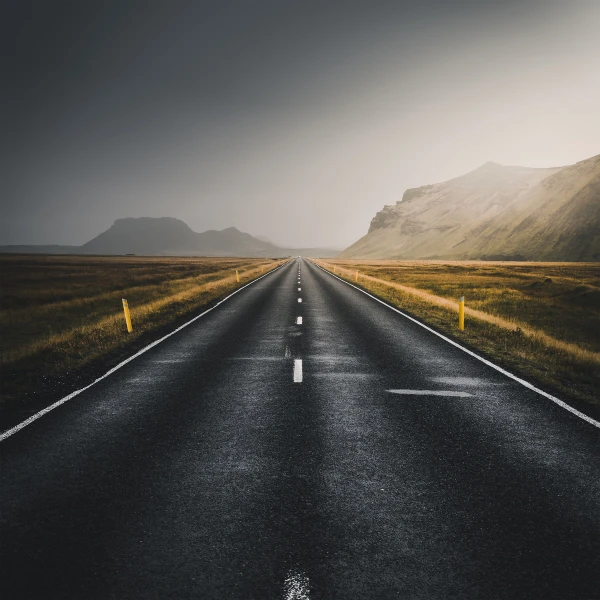 Photo of a road that disappears into the mountains on the horizon